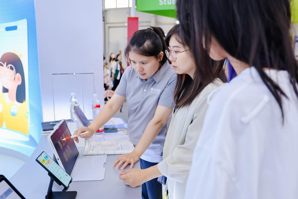 展区工作人员为参展观众讲解小猿AI学习机T4的各项功能 小猿全矩阵产品亮相2025服贸会 “AI超拟人1V1老师”成焦点